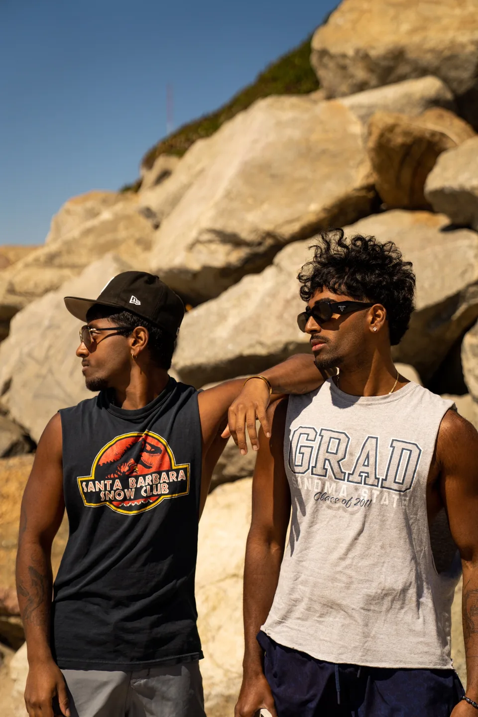 Two men posing together against sunlit rocks